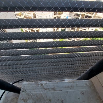 רשת הגנה נגד יונים מותקנת על מרפסת