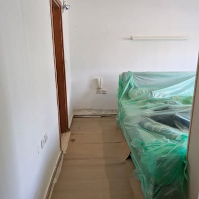 חדר עם רהיטים מכוסים בניילון לקראת שיפוץ