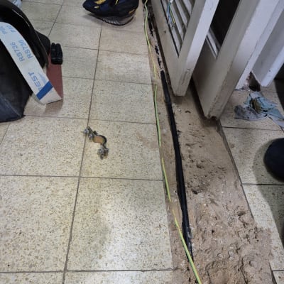 צינור חשוף ברצפה עם חוטי חשמל וכלי עבודה