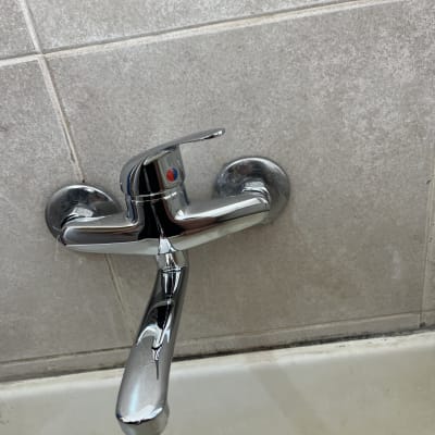 ברז כרום מותקן על קיר אריחים במקלחת