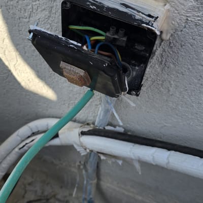 תיבת חיבורים חשמלית פתוחה עם חוטים צבעוניים