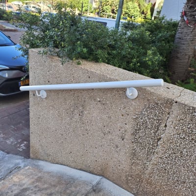 מעקה לבן מותקן על קיר חיצוני