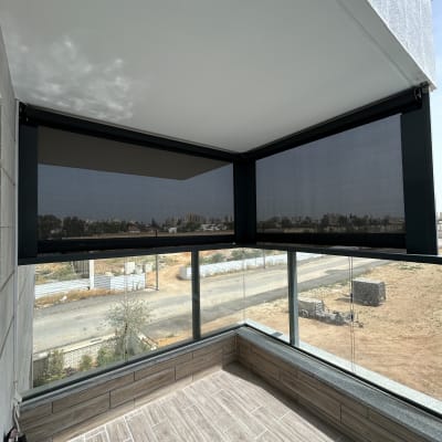 מרפסת עם סוככים כהים על חלונות זכוכית