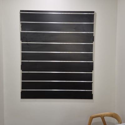 לוח שחור על קיר לבן עם כיסא ובקבוק ספריי