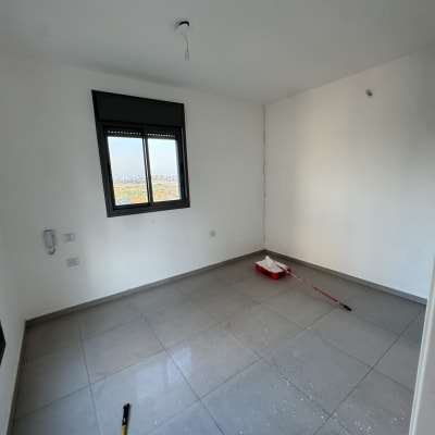 חדר ריק עם כלי צביעה על הרצפה