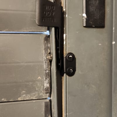 חלק ממנגנון תריס מתכת עם תפסן שחור