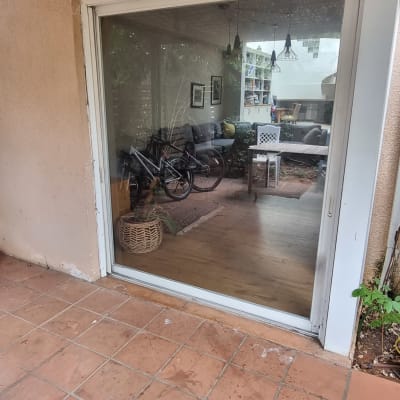 דלת זכוכית גדולה עם השתקפות של פנים הבית