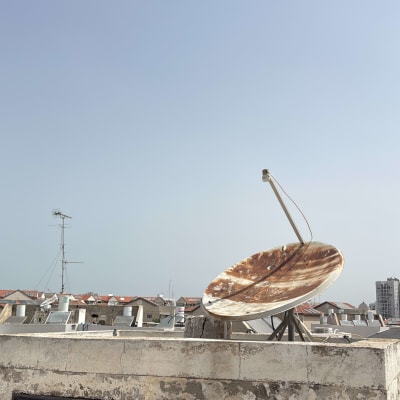 צלחת לוויין חלודה על גג בניין