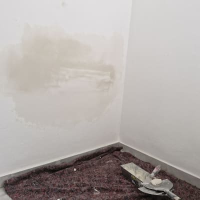 כלי עבודה ושפכטל על רצפה במהלך שיפוץ קיר