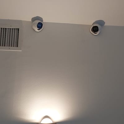 שתי מצלמות אבטחה מותקנות על תקרה לבנה