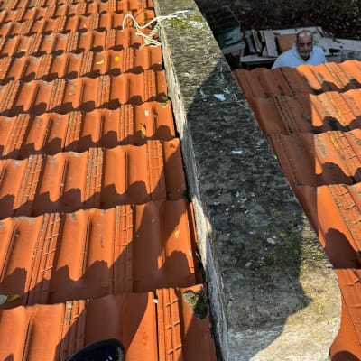 אדם על גג רעפים עם חוטים וכלים