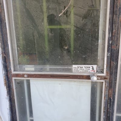 דלת זכוכית עם ידית מתכת ושלט מנעולן