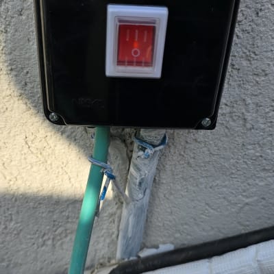 מתג חשמלי עם חוטים ירוקים ולבנים מחוברים לקיר