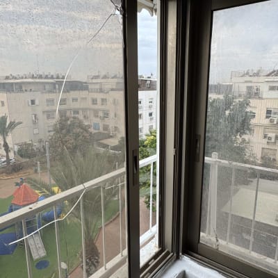 חלון עם סדק המשקיף על נוף עירוני