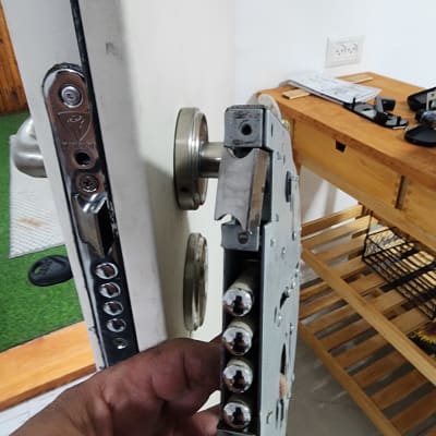 מנעול דלת עם בריחים גליליים ביד של מנעולן