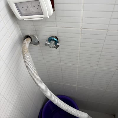 צינור מים מחובר לשקע חשמלי וקיר אריחים