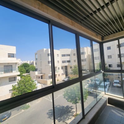 חלונות אלומיניום במרפסת עם נוף לבניינים