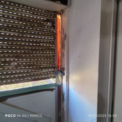 תריס שבור עם קיר מתקלף ותיקון