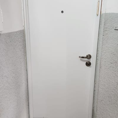 דלת לבנה עם ידית מתכת ועינית