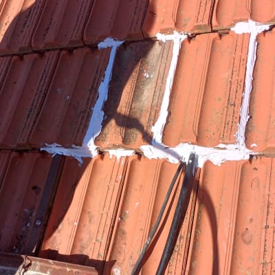 תיקון רעפים עם חומר איטום על גג