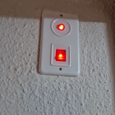 מתג חשמלי עם נורות אדומות על קיר