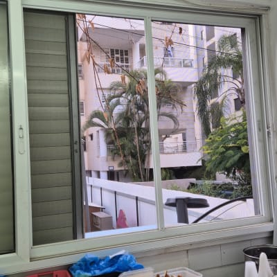 חלון אלומיניום עם מסגרת לבנה ומסך רשת