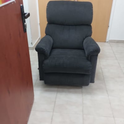 כורסה אפורה על רצפת אריחים לבנה