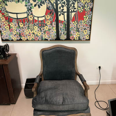 כורסה מרופדת בבד כהה עם כרית ישיבה גדולה