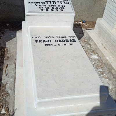 מצבה לבנה עם כיתוב בעברית ואנגלית