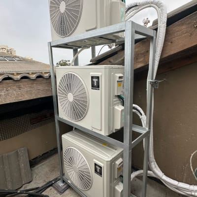 שלוש יחידות חיצוניות של מזגנים מותקנות על מתקן מתכת