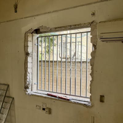 חלון עם סורגים בקיר תחת שיפוץ