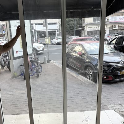 חלון זכוכית עם נוף לרחוב ומכוניות בחוץ