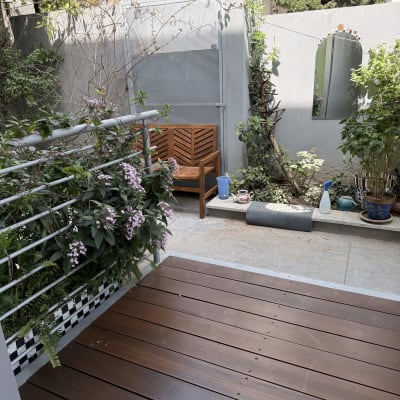 דק עץ עם צמחים ופרחים בגינה