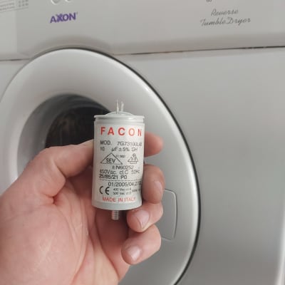 קבל חשמלי ביד מול מכונת כביסה