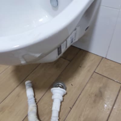 כיור עם צינור פלסטיק מנותק על הרצפה