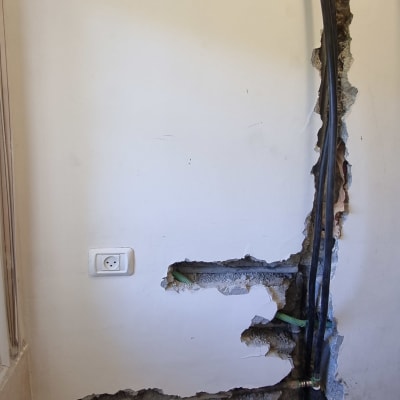 צינורות חשופים בקיר עם חיבורים ותיקונים
