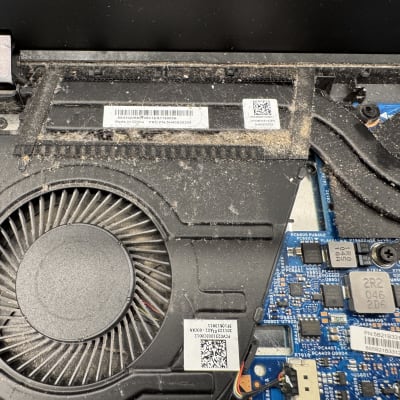 מאוורר ומעגלים מודפסים בתוך מחשב נייד עם אבק