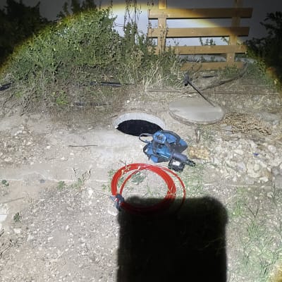 פתח ביוב עם כלי עבודה ואדמה