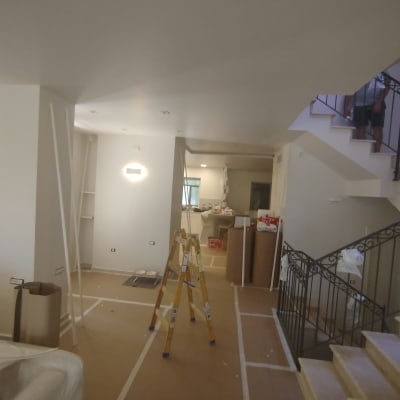 סולם צהוב, קירות לבנים, רצפה מכוסה בנייר