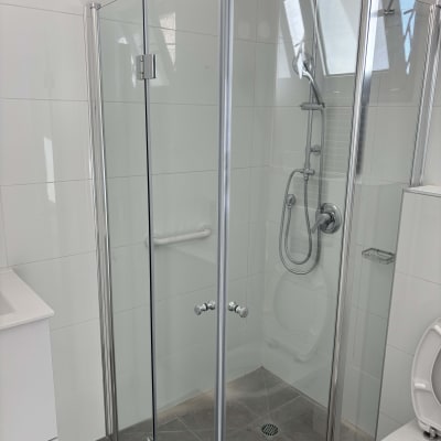 מקלחון זכוכית עם דלתות מתכת וברז מקלחת