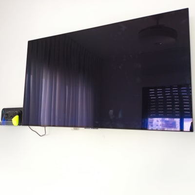 טלוויזיה מותקנת על קיר עם מדף קטן