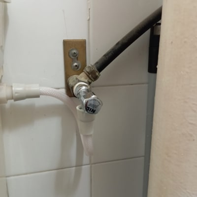 צינור ומחבר על קיר אריחים לבנים