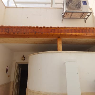 גג עץ עם קורות תומכות מעל כניסה לבית