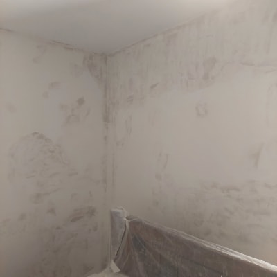 קיר עם טיח מתקלף ויריעות פלסטיק לכיסוי