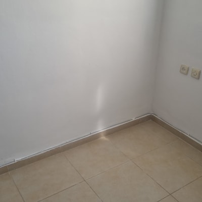 קיר צבוע עם שקעי חשמל ורצפת אריחים