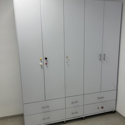 ארון לבן עם דלתות ומגירות בחדר ריק