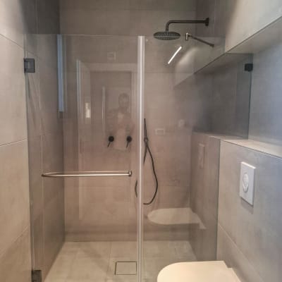 מקלחת עם דלת זכוכית, ראש מקלחת עגול וברז שחור