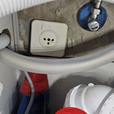 שקע חשמל עם תקע תלת פיני ליד צינור גמיש