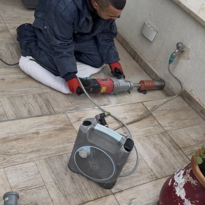 אדם עובד עם כלי עבודה על רצפה מרוצפת