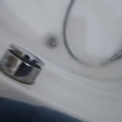 צינור מתכת באמבטיה עם ניקוז